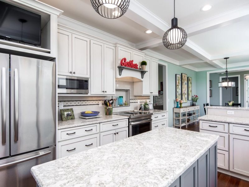 Wall of custom white kitchen cabinets and large quartz island