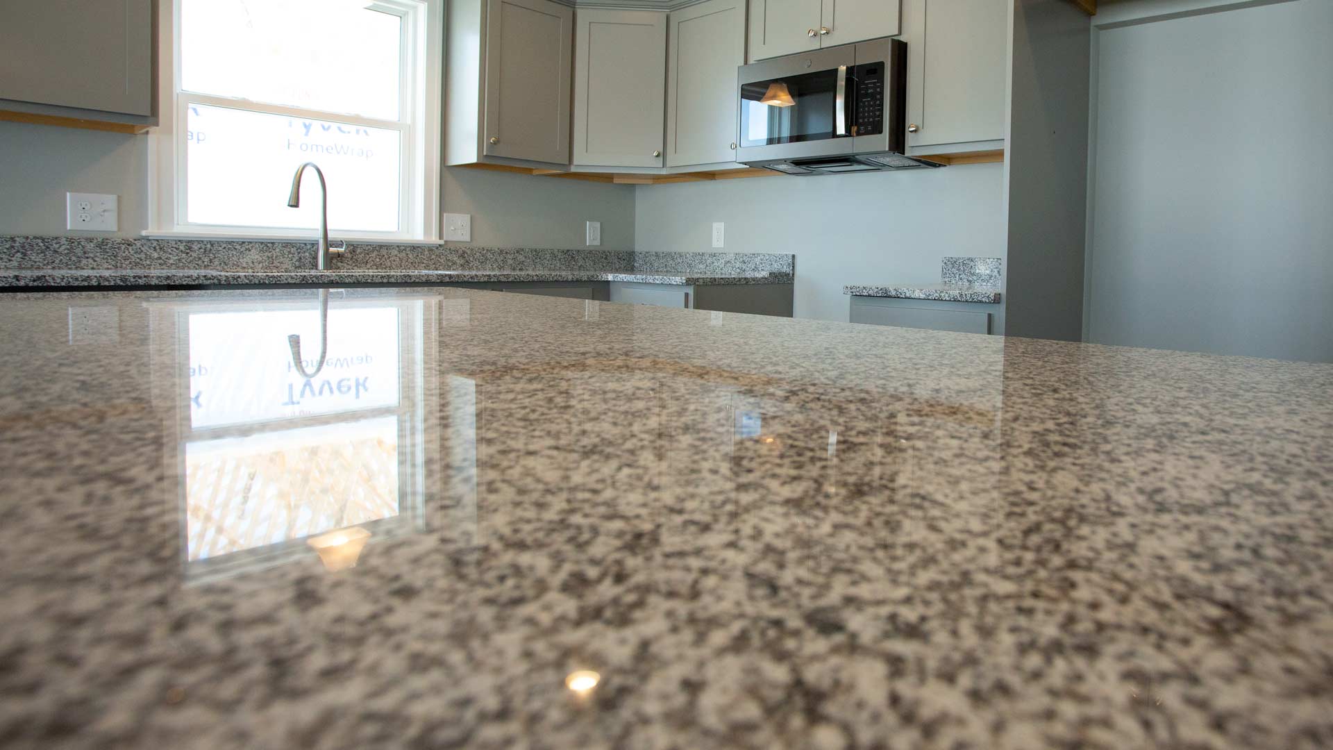 Granite countertop with flecks of white, grey and black on kitchen island