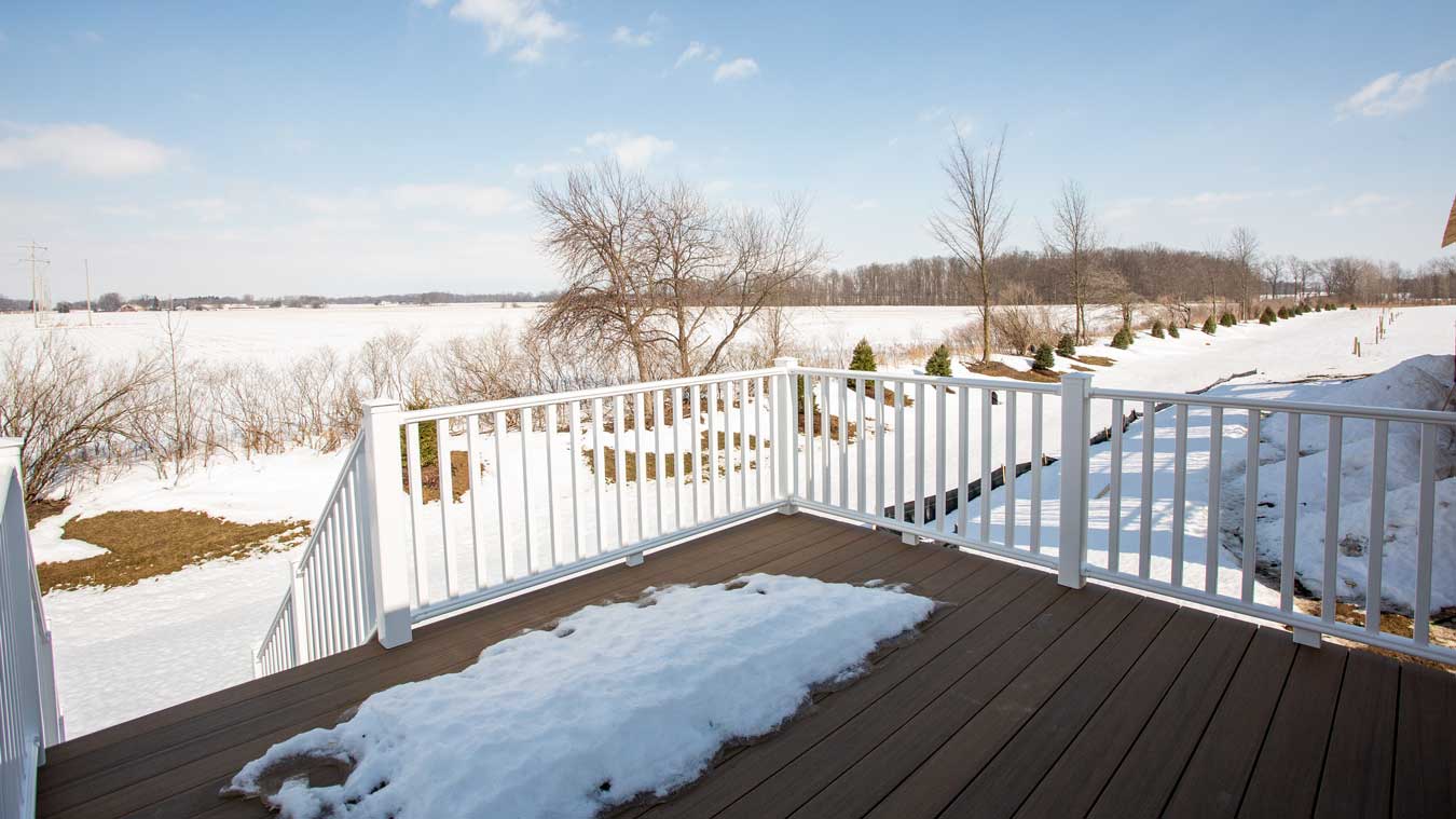 A composite deck with vinyl railing connected to an attached unit condo in St Johns, MI